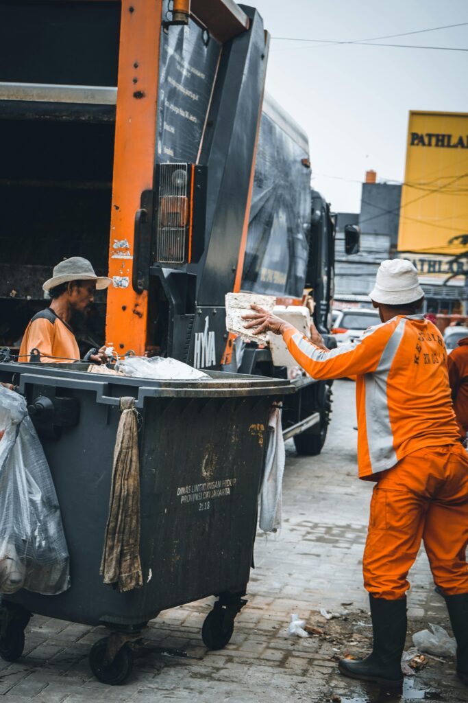 Trashmen Loading a Container Before Pouring it Into the Garbage Truck